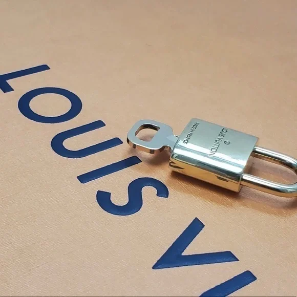 NEAR MINT Louis Vuitton lock and key set.